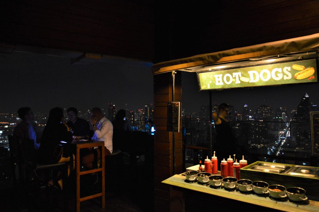 タイでのゴルフの後の1杯。バンコクのルーフトップバー「オクターブ」のバーフロアに置いてあるホットドッグ屋台のオブジェ